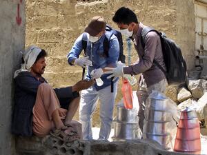 Yemeni volunteers spray disinfectant on the hands of a man in the one of Sanaa's impoverished neighbourhoods, on March 30, 2020, amid concerns of a coronavirus outbreak. MOHAMMED HUWAIS / AFP