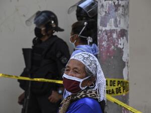 An elderly woman wears a face mask against the spread of the new coronavirus as he queues to enter a bank in San Salvador on March 30, 2020. Thousands of Salvadorans in different parts of the country were desperately seeking to receive the aid of $300 from the government for the purchase of food Monday during the outbreak of the new coronavirus pandemic.  Yuri CORTEZ / AFP