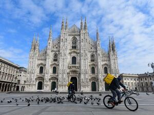 Two cyclists working for the food delivery service Glovo ride their bike across a deserted Piazza Duomo in Milan, on March 31, 2020, during the country's lockdown aimed at curbing the spread of the COVID-19 infection, caused by the novel coronavirus. Piero Cruciatti / AFP