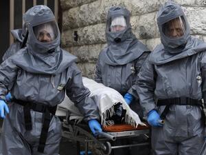 Workers at Israel's religious burial society Chevra Kadisha wearing protective equipment, carry the body of a patient who died from complications of Coronavirus (COVID-19) infection, at the Shamgar Funeral Home in Jerusalem, on April 1, 2020. Ahmad GHARABLI / AFP