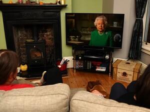 A picture shows a family in Birkenhead, northwest England on April 5, 2020 watching Britain's Queen Elizabeth II deliver a special address to the UK and Commonwealth recorded at Windsor Castle in relation to the coronavirus outbreak. Queen Elizabeth II urgeed people to rise to the challenge posed by the coronavirus outbreak, in a rare special address to Britain and Commonwealth nations on Sunday. PAUL ELLIS / AFP