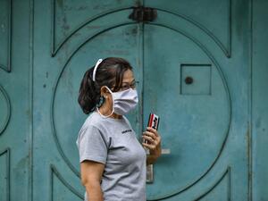 A women wearing a face mask, amid concerns of the COVID-19 coronavirus, walks on a street in Banda Aceh on April 7, 2020. CHAIDEER MAHYUDDIN / AFP