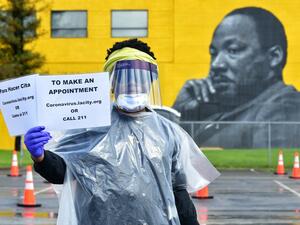 Dressed in protective gear, university student working on her master's degree Jacquelyn Augustine displays information for arranging COVID-19 testing amid the coronavirus pandemic on April 8, 2020, on the first day of testing at the Charles R. Drew University of Medicine in south Los Angeles. AFP
