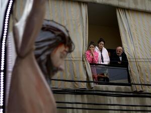 Lebanese Christians watch a crucifix shrine car procession on Good Friday, from their balcony in the dominantly Christian suburb of Dekwaneh, east of the capital Beirut, on April 10, 2020, during the novel coronavirus pandemic crisis. PATRICK BAZ / AFP