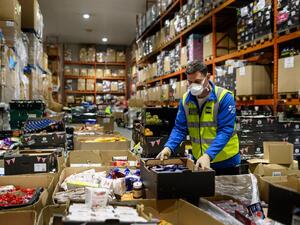 Richard Humphrey, Senior Coordinator for the charity 'His Church', helps prepare pallets of food and supplies which will be distributed to charities and community support networks across the UK from their warehouse near Market Rasen, northern England on April 14, 2020. AFP