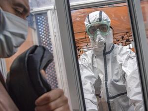 Members of the medical staff at the Mohammmed V military hospital, wearing protective outfits, receive a patient to be tested for the novel coronavirus, in the Moroccan capital Rabat on April 15, 2020 FADEL SENNA / AFP