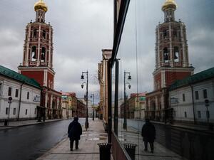 A woman walks on a deserted street past the Vysoko-Petrovsky Monastery in downtown Moscow on April 16, 2020, during a strict lockdown in Russia to stop the spread of the COVID-19 coronavirus. Dimitar DILKOFF / AFP