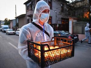 A church volunteer wearing protective equipment brings holy light to the people at their home during Christian Orthodox Easter celebration prior to the religious service held with closed doors due to the social distancing rules imposed by the state of emergency in Bucharest April 18, 2020, amid the COVID-19 pandemic caused by the novel coronavirus. Until now Romania registered 8,418 confirmed cases of people infected by coronavirus, 421 deaths and 1,730 healed persons. Daniel MIHAILESCU / AFP