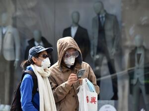 People wear face masks as they walk on a street on April 21, 2020 in front of closed stores in Munich, southern Germany, amid the new coronavirus COVID-19 pandemic. Christof STACHE / AFP