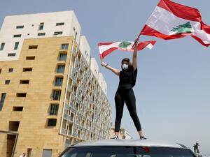 An anti-government protester stands of the top of a car during a convoy protest in the Lebanese capital Beirut on April 22, 2020, amid an economic crisis exacerbated by the coronavirus pandemic. ANWAR AMRO / AFP