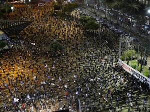 Israelis wearing protective masks and dressed mainly in black, take part in a demonstration on April 25, 2020, in Rabin Square in the coastal city of Tel Aviv, to protest what they consider threats to Israeli democracy, against the backdrop of negotiations between Prime Minister Benjamin Netanyahu and his ex-rival Benny Gantz. The protesters stood two meters apart from each other, thereby respecting the social distancing measures in force to fight the COVID-19 pandemic. JACK GUEZ / AFP
