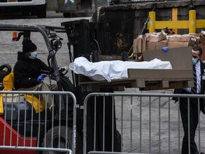 A worker uses a forklift to move a body outside of the Brooklyn Hospital on March 31, 2020 in New York, United States. Due to a surge in deaths caused by the Coronavirus, hospitals are using refrigerator trucks as make shift morgues. Stephanie Keith/Getty Images/AFP STEPHANIE KEITH / GETTY IMAGES NORTH AMERICA / Getty Images via AFP