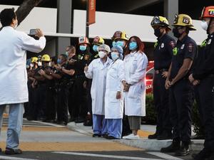 Members of the Glendale police and fire departments pose with healthcare workers as they pay tribute to the healthcare workers during a shift change at Glendale Memorial Hospital amid the coronavirus pandemic on April 16, 2020 in Glendale, California. AFP/File