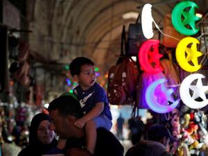 Palestinians walk past shops decorated ahead of the Muslim holy fasting month of Ramadan, in Jerusalem's old city, May 2. (AFP)