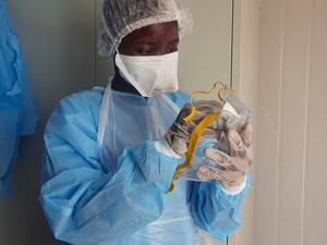 Medical staff of International Medical Corps (IMC) put on Personal Protective Equipment (PPE) at the isolation ward of Ministry of Health Infectious Disease Unit in Juba, South Sudan, on April 24, 2020. The national facility hosts South Sudan’s fifth case of the COVID-19 Coronavirus, who was admitted yesterday. Alex McBride / AFP