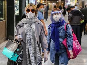 Shoppers clad in protective gear, including face masks and shields and latex gloves, due to the COVID-19 coronavirus pandemic, walk through the Tajrish Bazaar in Iran's capital Tehran on April 25, 2020 during the Muslim holy month of Ramadan. ATTA KENARE / AFP
