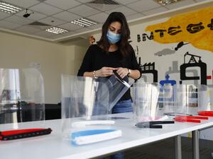 Aya Dessouky, public relations specialist at the Giza Systems Education Foundation, assembles a newly-fabricated protective face shield, before sending it for use by medical professionals treating COVID-19 coronavirus patients, at their premises in the New Cairo suburb east of the Egyptian capital on April 8, 2020. (AFP)