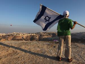  this file photo taken on September 7, 2009 a right wing Israeli boy holds his national flag during a protest near the biggest Jewish settlement of Maale Adumim, east of Jerusalem. (AFP/File Photo)