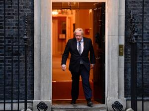 Britain's Prime Minister Boris Johnson walks of 10 Downing Street in central London on April 30, 2020, to participate in a national "clap for carers" to show thanks for the work of Britain's NHS (National Health Service) workers and other frontline medical staff around the country as they battle with the novel coronavirus pandemic, in the doorway of ˜Britain is "past the peak" of its coronavirus outbreak, Prime Minister Boris Johnson said Thursday, despite recording another 674 deaths in the last 24 hours, 