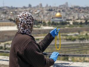 A Palestinian woman holds prayer beads after performing the second Friday prayer of the Muslim holy month of Ramadan at the Mount of Olives, as she looks at the Old City of Jerusalem and the closed-down Aqsa Mosque compound, on May 1, 2020, amid heightened security and social distancing measures due to the COVID-19 pandemic. AHMAD GHARABLI / AFP