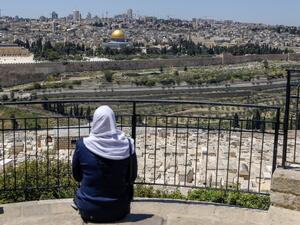 A Palestinian woman looks from the Mount of Olives at the Old City of Jerusalem and the closed-down Aqsa Mosque compound, after the second Friday prayer of the Muslim holy month of Ramadan, on May 1, 2020, amid heightened security and social distancing measures due to the COVID-19 pandemic. AHMAD GHARABLI / AFP