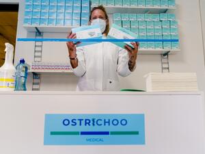 A woman poses with boxes of protective facemasks in pop-up facemask shop, in Rotterdam, on May 5, 2020. Marco DE SWART / ANP / AFP