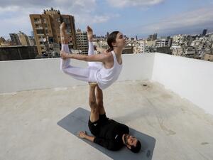 In this file photo taken on April 27, 2020 Lebanese Yoga instructor Rabih el-Medawar, 29, practises Acroyoga with his Ukranian wife, fellow Yoga instructor and professional choreographer, Alona Aleksandrova, 24, on the roof of their apartment building in Beirut's Ain El-Remmaneh district on April 27, 2020 during the coronavirus (COVID-19) virus epidemic. (AFP/File)