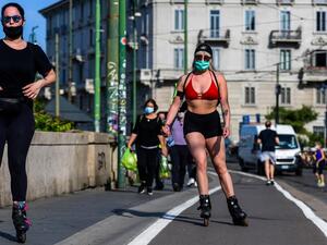 Women wearing a face mask roller skate along the Navigli canals in Milan on May 8, 2020 during the country's lockdown aimed at curbing the spread of the COVID-19 infection, caused by the novel coronavirus. Miguel MEDINA / AFP