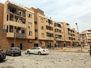 A fighter loyal to Libya's UN-recognised Government of National Accord (GNA) walks through debris along a street near a destroyed apartment balcony, following bombardment earlier in the day in the residential Bab Bin Ghashir neighbourhood of Libya's capital Tripoli, on May 9, 2020. Prior rocket and shell fire on Tripoli had killed at least 13 civilians and two policemen, Libya's UN-recognised government said on May 8. The GNA accused forces loyal to strongman Khalifa Haftar of carrying out the attacks, whic