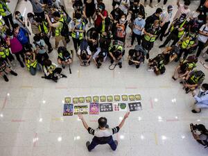 Journalists watch a pro-democracy demonstrator protests calling for the city's independence in Hong Kong on May 10, 2020. ISAAC LAWRENCE / AFP