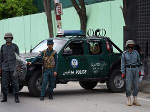 Afghan security personnel stand guard as civil society activists (not pictured) hold banners and shout slogans against the Iranian government during a protest in front of the Iranian embassy in Kabul on May 11, 2020. (AFP)