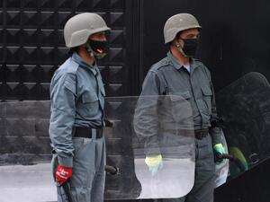 Afghan security personnel stand guard as civil society activists (not pictured) hold banners and shout slogans against the Iranian government during a protest in front of the Iranian embassy in Kabul on May 11, 2020. Afghanistan has recovered 18 bodies of migrants who were allegedly beaten and tortured before being forced into a river by Iranian border guards last week, a senior Afghan official said on May 8. Afghan authorities are investigating claims the migrants drowned while illegally crossing into neig
