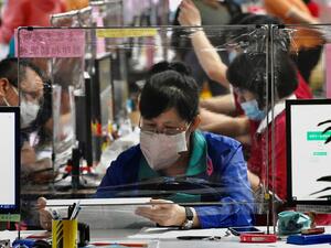 A local resident (C) wearing a face mask due the COVID-19 pandemic sits behind a plastic partition as she submits her tax documents at the Taipei National Taxation Bureau in Taipei on May 12, 2020. Sam Yeh / AFP