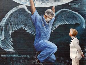 A woman looks at a mural of a health worker with wings holding a globe on International Nurses Day in Melbourne on May 12, 2020. As frontline hospital staff are constantly facing the risks from the COVID-19 coronavirus outbreak, the world is marking International Nurses Day, celebrated around the world every May 12, the anniversary of Florence Nightingale's birth. William WEST / AFP