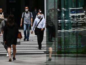 People wearing face masks amid the COVID-19 coronavirus outbreak walk across a street in Tokyo on May 13, 2020. Charly TRIBALLEAU / AFP