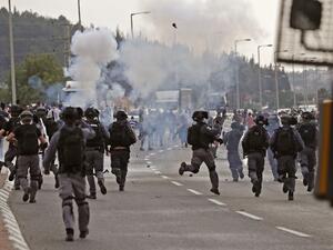 Tear gas fumes are seen as Israeli security forces run during clashes with protesters in a demonstration near the northern Arab Israeli city of Arara on May 14, 2020, after a man was shot to death after stabbing a security guard outside Tel Hashomer Hospital. Ahmad GHARABLI / AFP