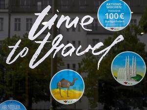 "Time to Travel" is written on the window of a travel agency on May 18, 2020 in Berlin amid the novel coronavirus COVID-19 pandemic. To halt transmission of the coronavirus, many countries have slammed borders shut and banned tourism, leaving planes grounded and cruise ships idle at ports while hotels are left empty. John MACDOUGALL / AFP