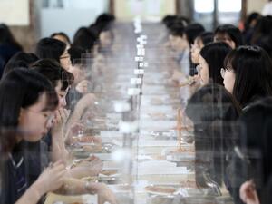 Students sit behind protective screens as a preventative measure against the COVID-19 novel coronavirus as they eat lunch at a high school in Daejeon on May 20, 2020. Hundreds of thousands of South Korean students returned to school on May 20 as education establishments started reopening after a coronavirus delay of more than two months.  Yonhap / AFP