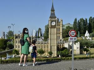 A model of a customs road sign is seen at the mock border of the United Kingdom and the European Union, a visitors look at a model of Big Ben, during the reopening of the 'Mini-Europe' theme park of small-scale models of European capitals and their landmarks, in Brussels on May 20, 2020. JOHN THYS / AFP