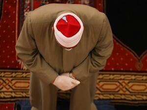 A Muslim cleric takes part in a morning prayer to celebrate the Eid al-Fitr holiday while wearing gloves and maintaining social distancing due to the COVID-19 pandemic, at Mohammed al-Amin Mosque in the Lebanese capital Beirut's downtown district on May 24, 2020. ANWAR AMRO / AFP