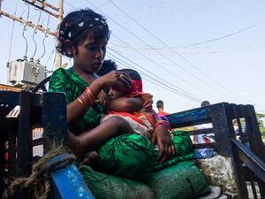 A girl holds a baby at the Aung Mingalar quarter for Rohingya Muslims as they observe the first day of the Eid al-Fitr holiday, which marks the end of the Islamic holy month of Ramadan, in Sittwe, Myanmar's Rakhine State on May 24, 2020. AFP