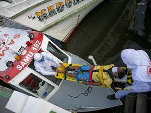 Health personnel of a medical emergency response service carry Brazilian Eladio Lopes, 79, -infected with the new coronavirus- on a stretcher to be transferred on an ambulance boat from the community of Portel to a hospital in Breves, on Marajo island, Para state, Brazil, on May 25, 2020. Ambulance boat services allow critical COVID-19 patients to be tranferred in very remote areas surrounded by water in Brazil. TARSO SARRAF / AFP