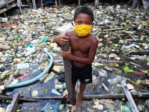 A boy from the Educandos riverside community wears a face mask during the COVID-19 coronavirus pandemic in Manaus, the Amazon on May 26, 2020. The Nossa Senhora Perpetuo Socorro church has been handing out masks to impoverished members of its community to assist in the fight against the spread of the novel coronavirus. MICHAEL DANTAS / AFP