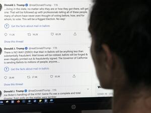 This illustration photo shows an editor in Los Angeles looking at the official Twitter account of US President Donald Trump on May 26, 2020, with two tweets by the president under which Twitter posted a link reading "Get the facts about mail-in ballots". Twitter labelled two of Donald Trump's tweets misleading on May 26, a first for the social media network which has long resisted calls to censure the US President over his frequent abuse, insults and false claims. Trump's tweets contended without evidence t