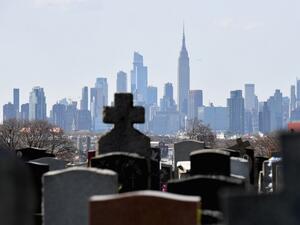 In this file photo Gravestones from Linden Hill Methodist Cemetery are seen with the Manhattan skyline in the background in Brooklyn, New York. The United States has now recorded more than 100,000 coronavirus-related deaths, Johns Hopkins University reported Wednesday -- a somber milestone and by far the highest total in the world. The country reported its first death about three months ago. Since then, nearly 1.7 million infections have been tallied nationwide, according to the Baltimore-based school. The 
