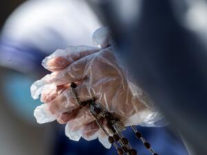 A Nun, wearing a protective glove, prays in St. Peter' Square at the Vatican on May 31, 2020, as Pope Francis leads the Regina Coeli prayer from his window for the first time after lockdown which was put into place to curb the spread of the COVID-19 infection, caused by the novel coronavirus. Tiziana FABI / AFP