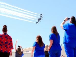 Hospital staff, including nurses, doctors and administrators, look on as the United States Navy Blue Angels pass over Medical City Dallas on May 06, 2020 in Dallas, Texas. (AFP)