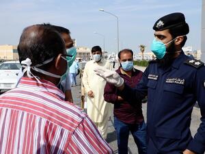 ضابط كويتي مع عمال وافدين/ أرشيفية