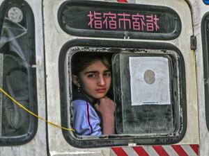 A girl looks from out the window of a vehicle leaving the town of Sarmin in Syria's northwestern Idib province, headed towards the border with Turkey, on March 10, 2020. Ozan KOSE / AFP