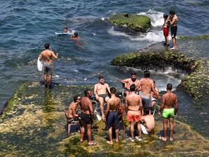 Residents of the Lebanese capital Beirut gather on the rocks along the seaside corniche, despite the lingering threat of the novel coronavirus, on May 31, 2020. ANWAR AMRO / AFP